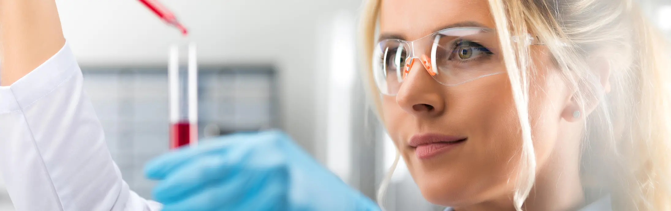 A lady is standing at the laboratory hood is working with a pipette, representing our analytical topics at Corporate Scientific Services.