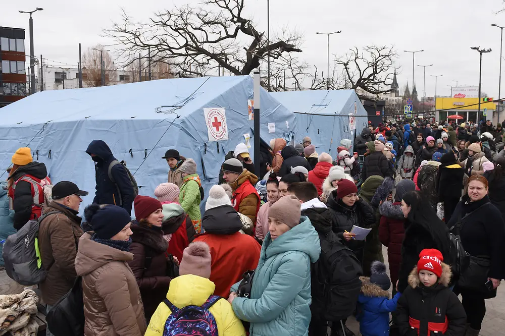 A group of refugees carrying their bags and walking ahead.