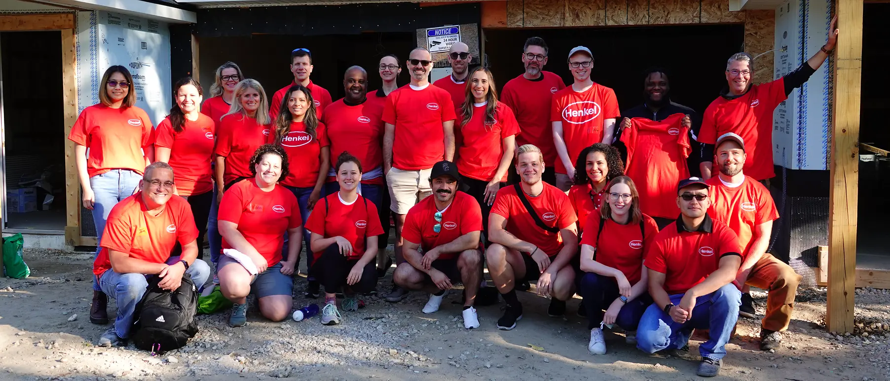 A group of people in red shirts smiling at camera