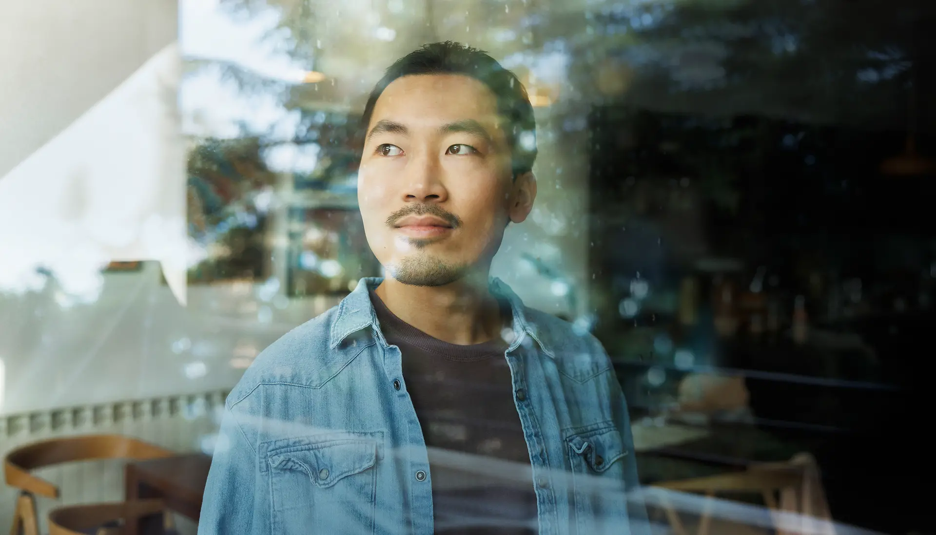 A man looks through a glass window.