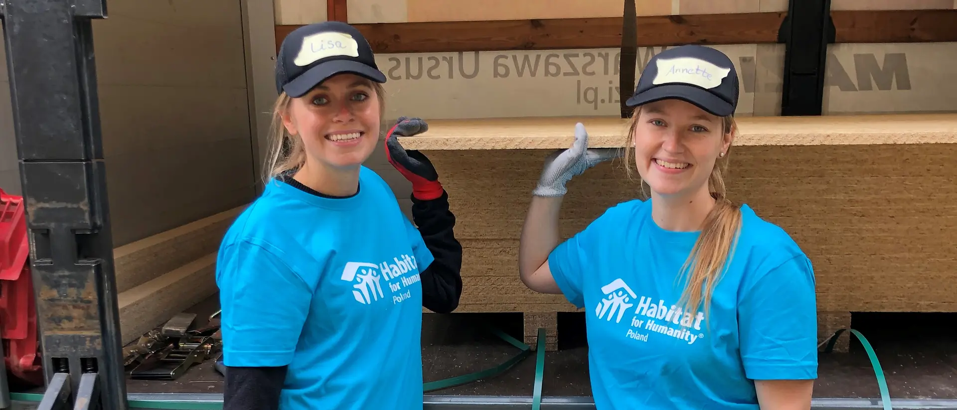 Two volunteers smile at the camera.