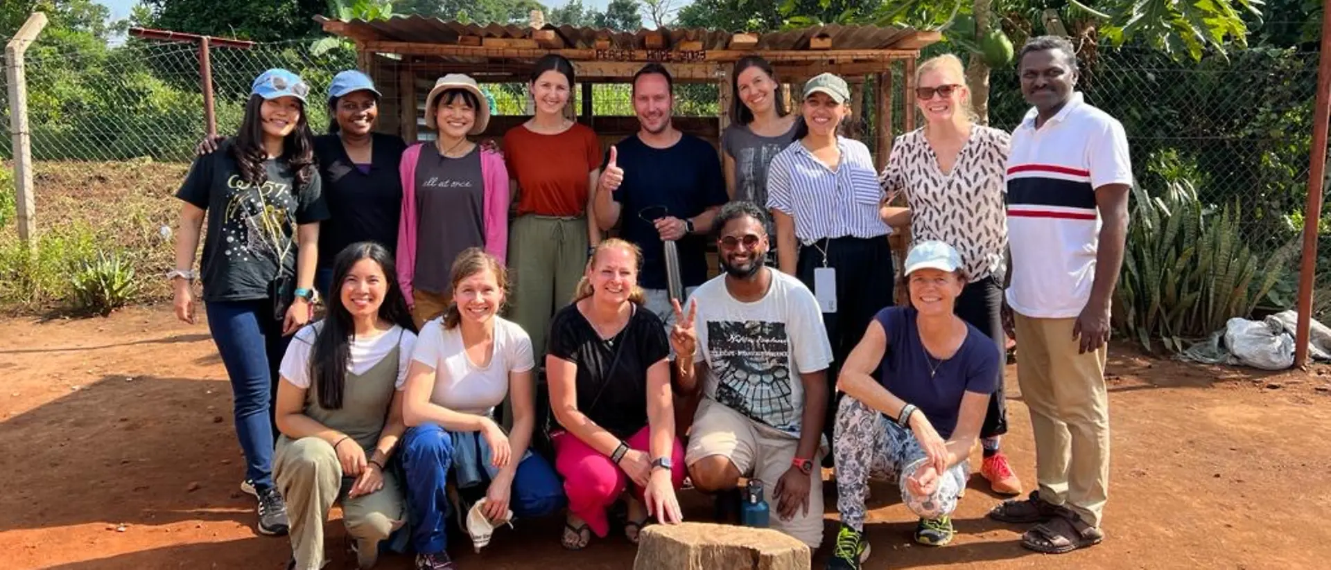 A group of volunteers in Uganda smiles at the camera.