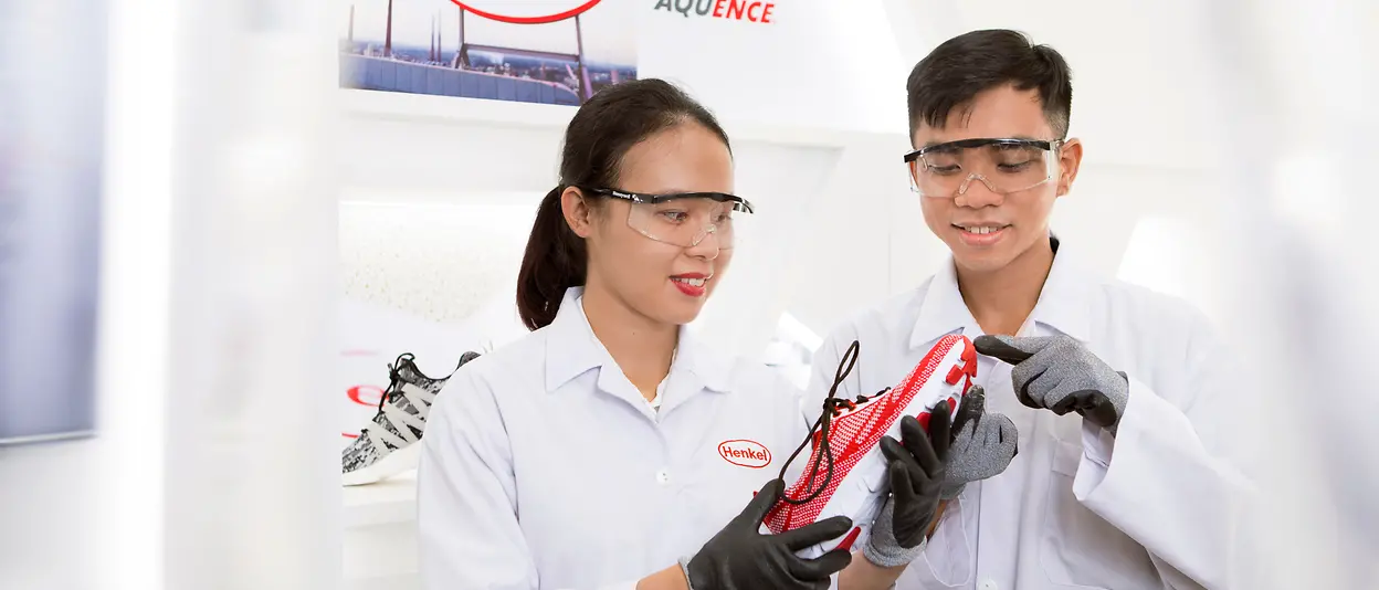 Application engineers inspect a shoe sole at the Henkel Adhesive Technologies Application Center in Ho Chi Minh City