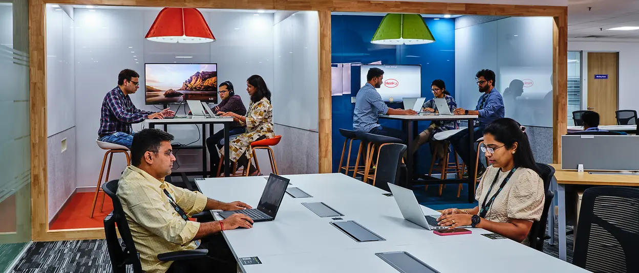 Several employees work alongside and with each other in an open office concept.