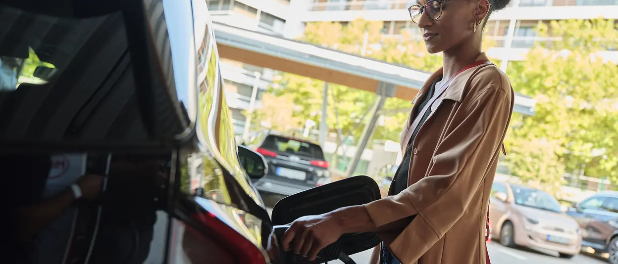 A woman is charging her electric car.